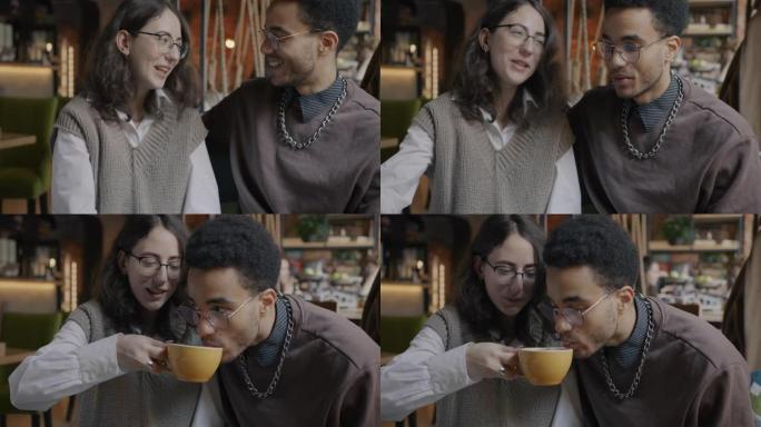 快乐的年轻女子给男朋友喝咖啡，和在咖啡馆享受约会的男人聊天