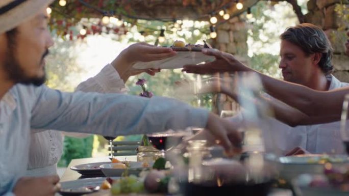 朋友在晚宴上庆祝吃地中海食物分享拼盘坐在餐桌上享受日落时的盛宴4k镜头