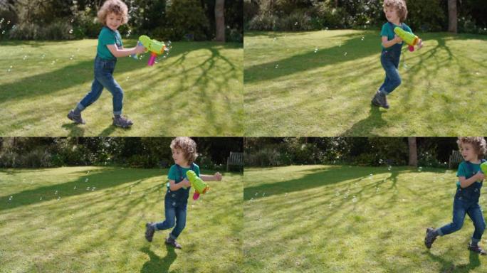 快乐的小男孩吹肥皂泡在阳光明媚的花园里玩玩具枪享受有趣的游戏有趣的顽皮的孩子享受夏天4k