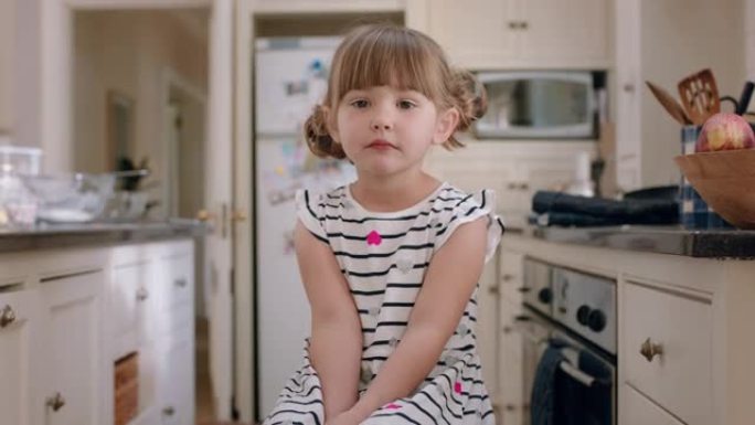 肖像美丽的小女孩微笑着可爱的表情坐在家里的厨房里