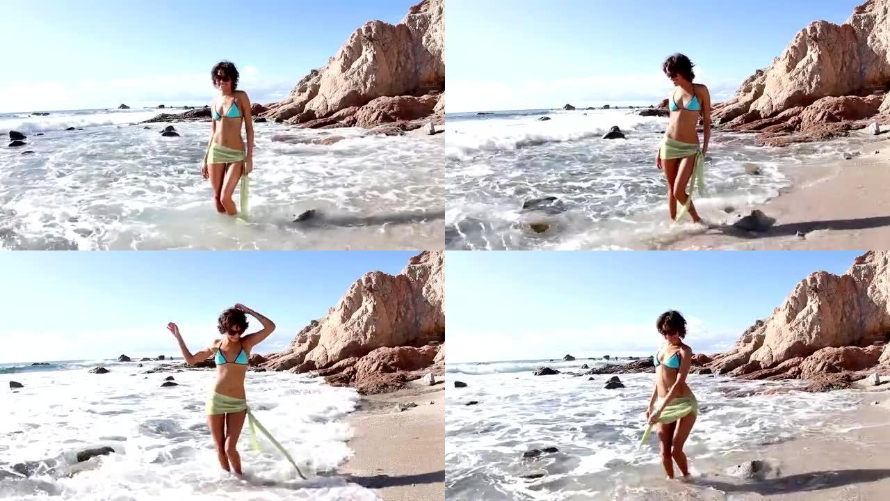 美丽的女孩在海滩上跳舞