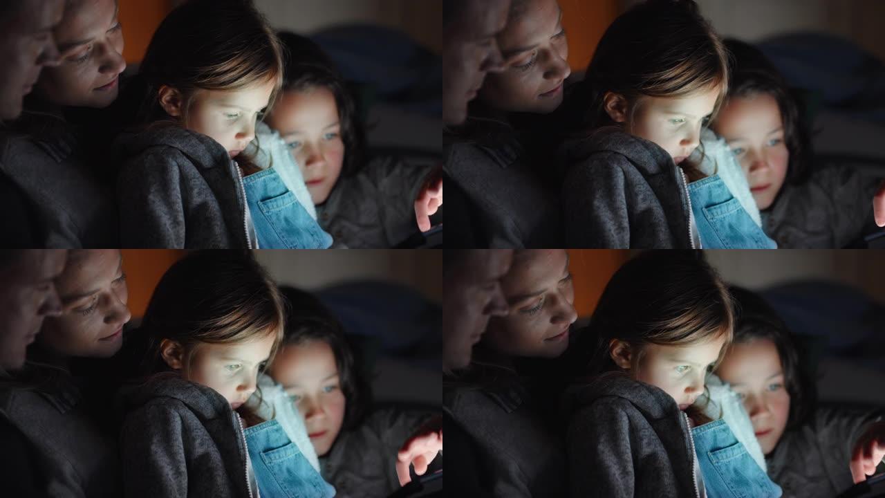 家庭使用平板电脑小女孩在触摸屏技术上与父母一起观看娱乐节目，享受睡前4k放松