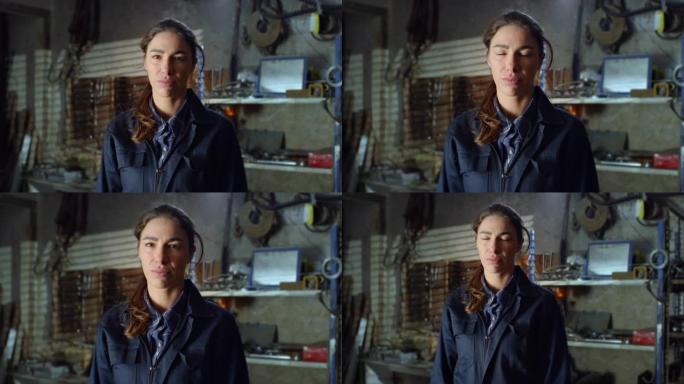 放大肖像，年轻的女机械师在她的维修车间看着相机。职业自信的焊工，挑战刻板印象