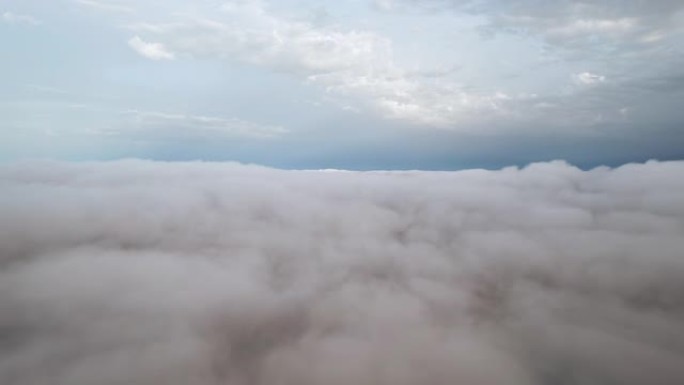 白云蓝天风景鸟瞰图移动。晚上，在明亮的阳光下，无人驾驶飞机在蓝天中飞出蓬松的云层。日落时，太阳隐藏在