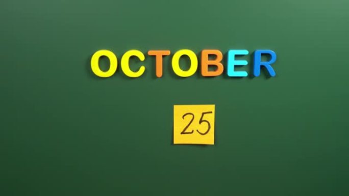 10月25日日历日用手在学校董事会上贴一张贴纸。25 10月日期。10月第二十五天。第25个日期编号