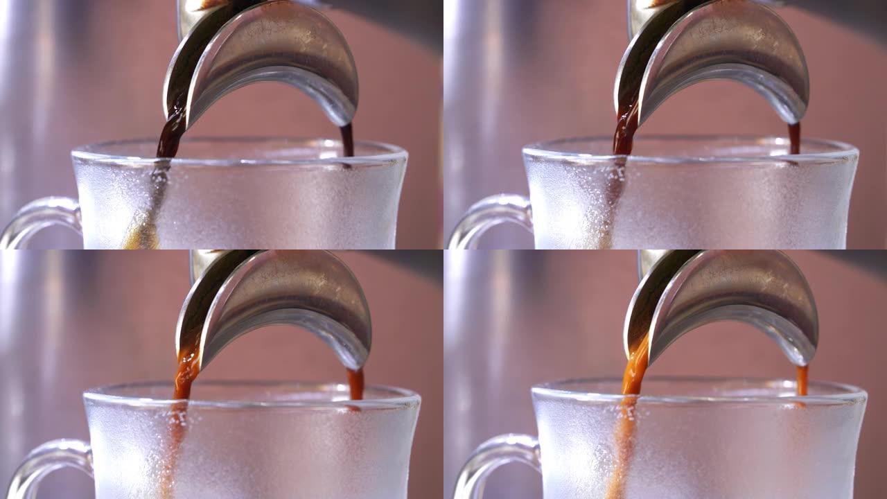 自动咖啡研磨机将咖啡分配到透明玻璃杯中。