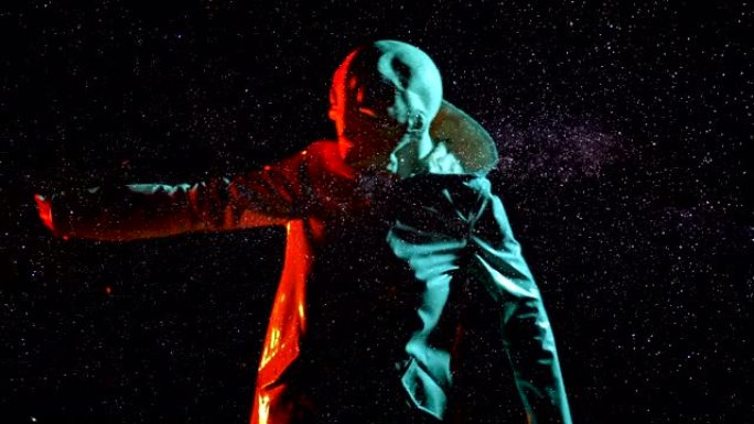 未来的外星人在星空空间、天空背景上跳舞。霓虹灯外星星球上人形动物的有趣模因镜头，伪装成穿着光滑雨衣的