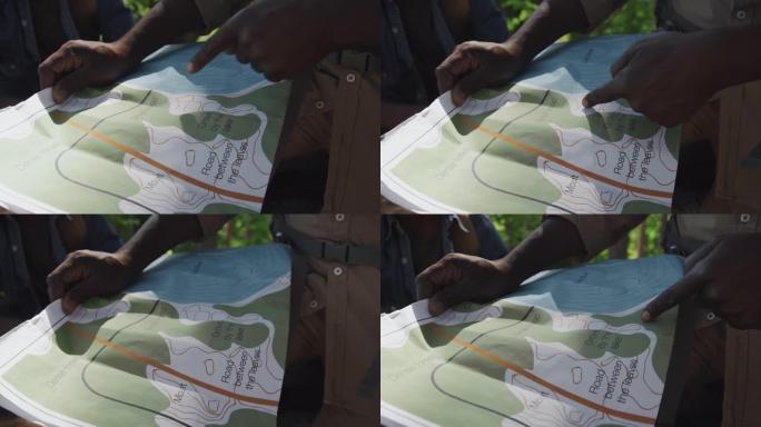 游客阅读纸质地图户外规划寻找路线查看地形