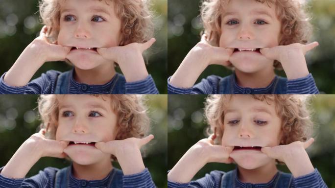肖像有趣的小男孩做鬼脸有趣的孩子喜欢在阳光明媚的公园做愚蠢的表情4k