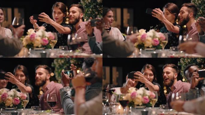 快乐的情侣享受晚宴，使用智能手机一起拍照享受与朋友团聚，在社交媒体上分享浪漫的夜晚4k镜头
