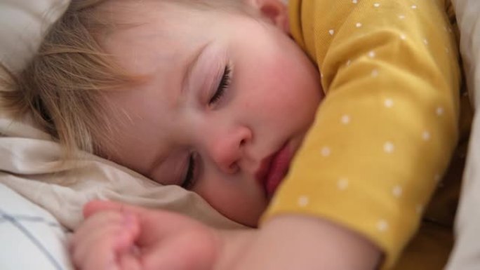 和平可爱的婴儿睡在家里的床上。睡眠新生儿概念。一岁的女婴在家庭室内背景下安静地睡觉。宁静的梦想。可爱
