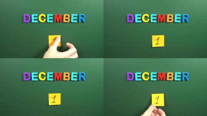 12月1日日历日用手在学校董事会上贴一张贴纸。1 12月日期。12月的第一天。第一个日期号。1天日历