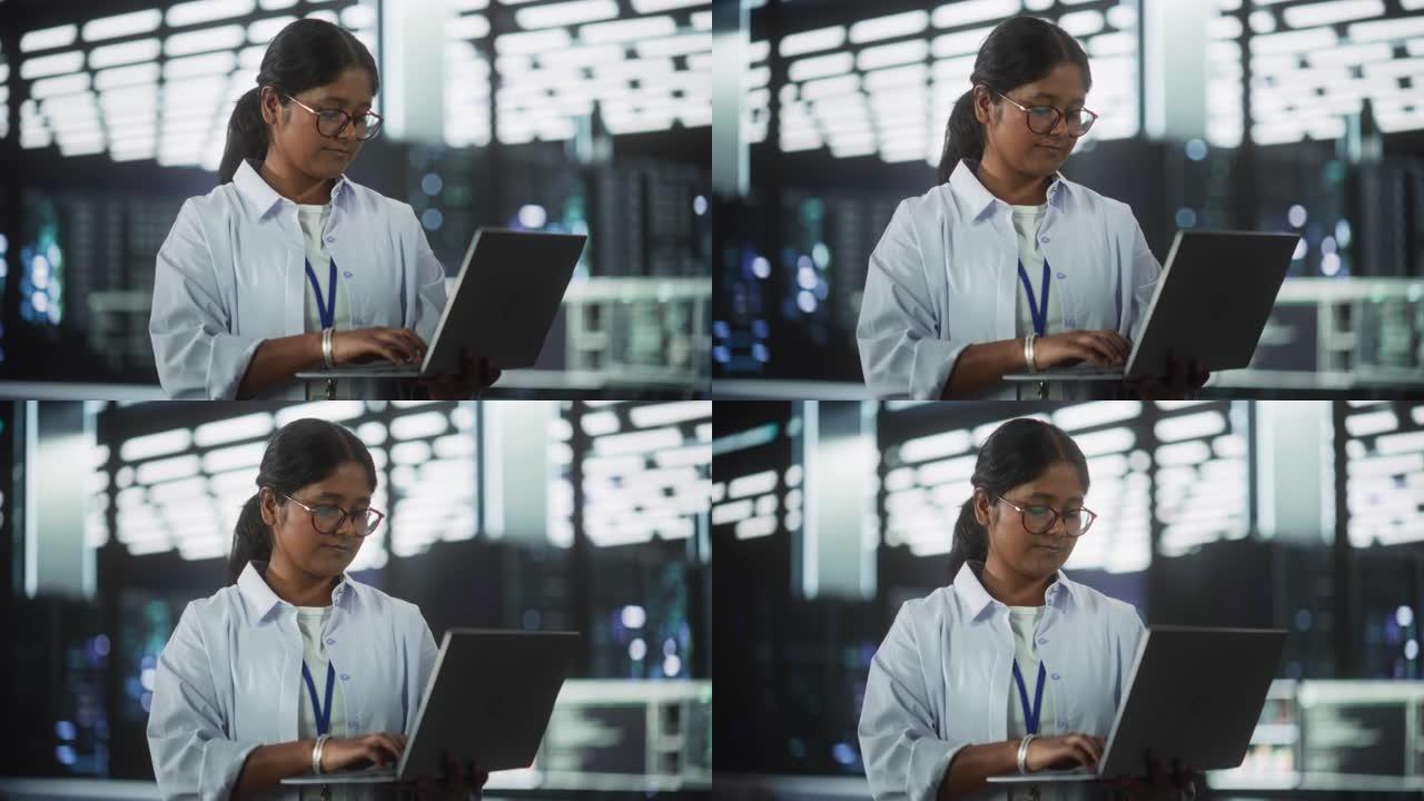技术软件工程部门经理站立并使用笔记本电脑的肖像。印度女性在办公室工作时专注于思考