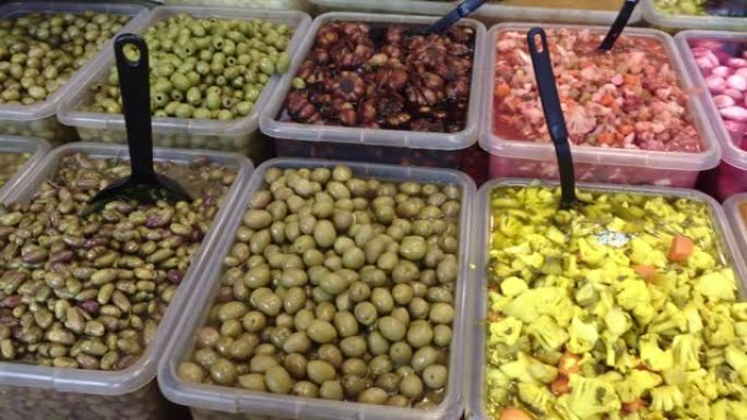 市场柜台上五颜六色的橄榄和腌菜