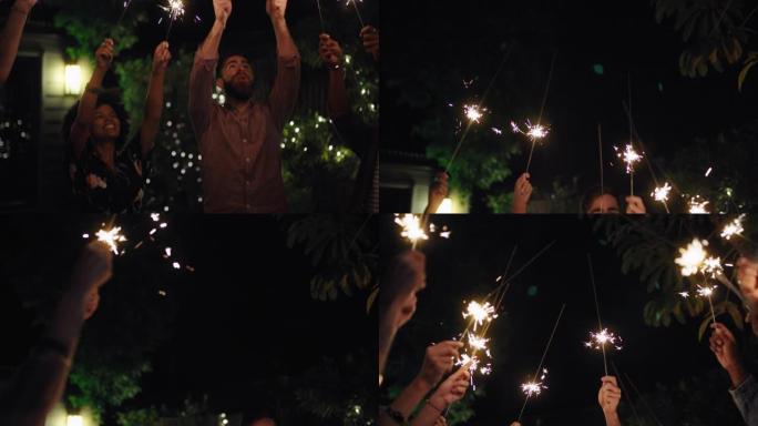 一群快乐的朋友在后院4k的宁静夜晚，一起用烟火庆祝新年