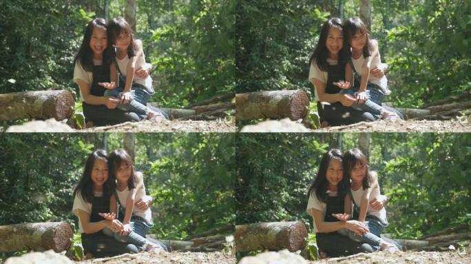 亚洲妈妈和女孩在自然公园里快乐着成群的蝴蝶。