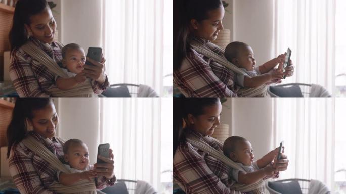 年轻的母亲和婴儿用智能手机与最好的朋友视频聊天，向蹒跚学步的快乐妈妈挥手，享受分享母亲的生活方式
