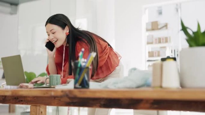 电话，笔记本电脑和创意设计师亚洲女性在她的时装办公室工作，以订购风格。与一位快乐的女员工在零售手机上