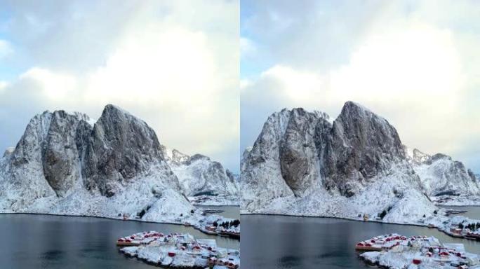 挪威罗弗顿岛鸟瞰图。瑞恩日出渔村的冬季与雪景山峰反映在水面上。挪威拥有红色的rorbu房屋。冬天下雪