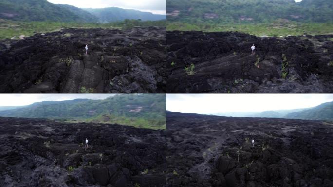游客站在岩石上，周围是黑色熔岩，快速绕行射击