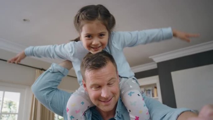 快乐的父亲肩上扛着小女孩爸爸抱着女儿在家享受俏皮游戏视频聊天概念4k