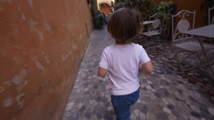 在意大利小巷跑步的小孩。无忧无虑的儿童探访在古老的鹅卵石上奔跑