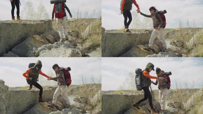 两个背着大背囊的年轻女孩在岩石上互相帮助