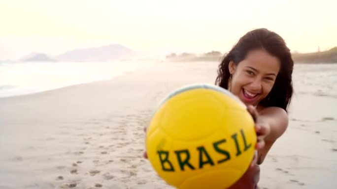 年轻的巴西女子与足球合影