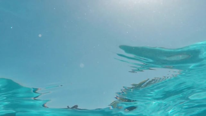 游泳池水下可以看到清澈的海水，明亮的阳光照在表面4k镜头