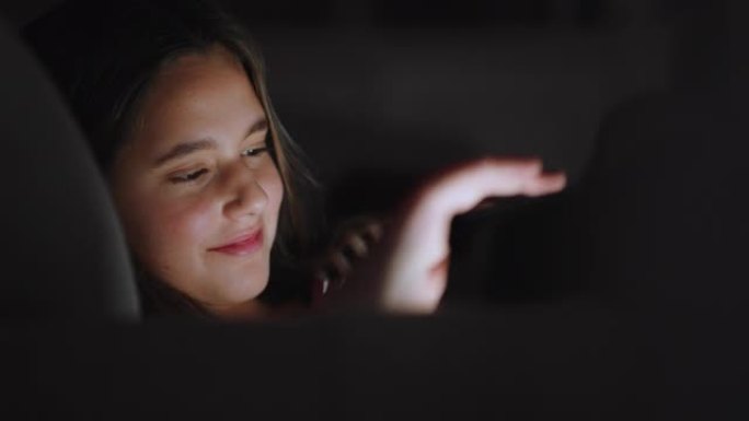 快乐的少女使用平板电脑观看夜间娱乐在线浏览享受放松的夜晚