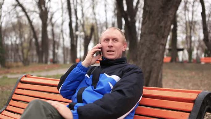 成年男子在公园里用手机聊天