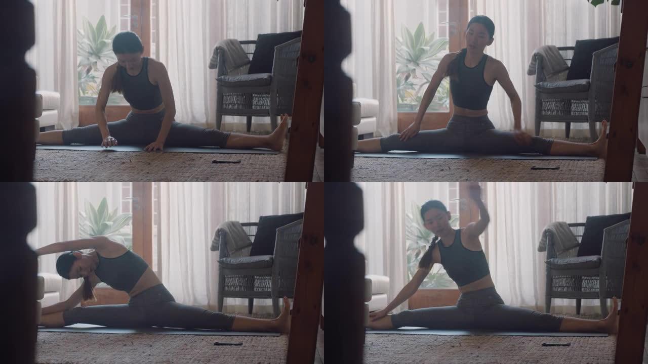 健康的亚洲女性在家锻炼，在客厅练习伸展运动，享受早晨健身锻炼
