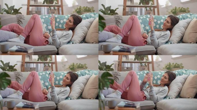 美女使用智能手机放松沙发发短信浏览社交媒体信息在家享受手机4k镜头