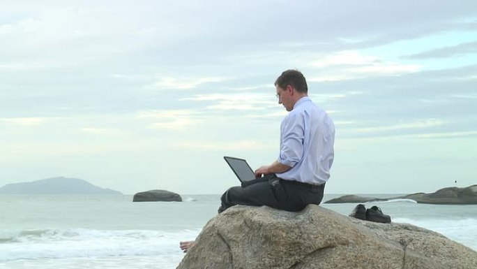 高清: 海滩上有笔记本电脑的商人