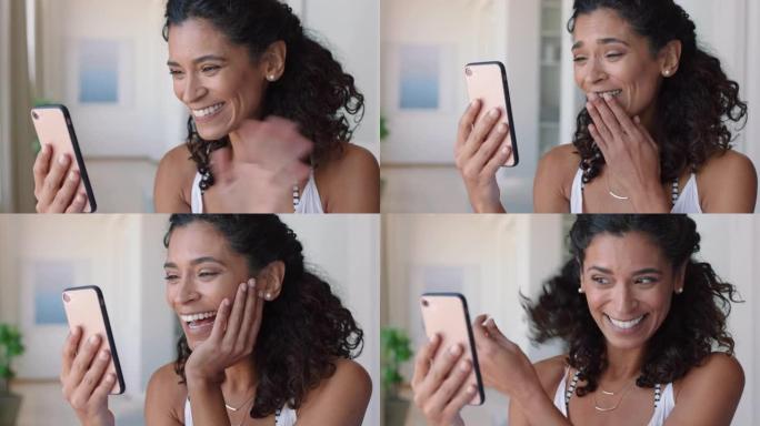 快乐的女人用智能手机视频聊天，对着婴儿微笑着在家享受手机聊天
