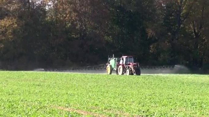 拖拉机在油菜田上喷洒化肥农药