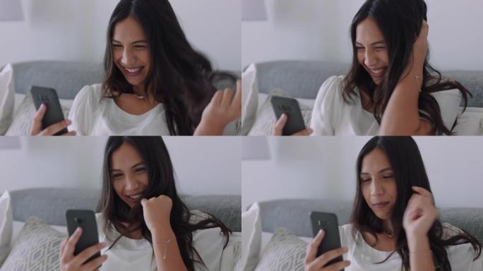 美丽的混血女人在家中使用智能手机进行视频聊天，炫耀发型与朋友分享生活方式，享受在线交流