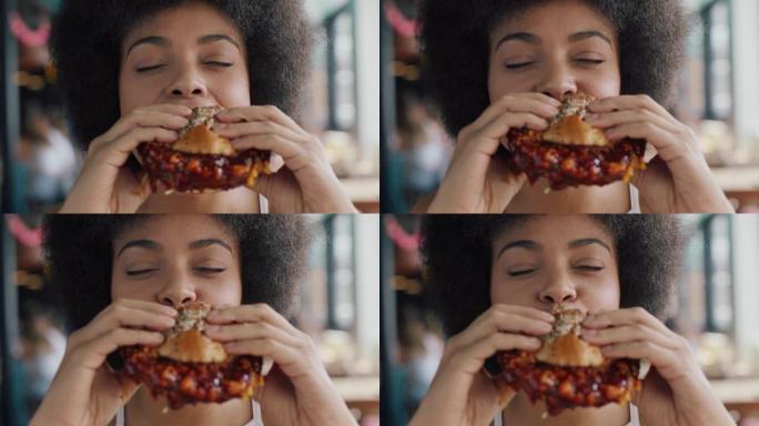 美丽的女人在餐厅吃汉堡，享受美味多汁的汉堡令人垂涎的餐非裔美国女性午餐4k