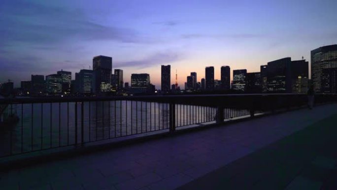东京铁塔和黄昏时的城市景观。筑地桥上的慢跑者。