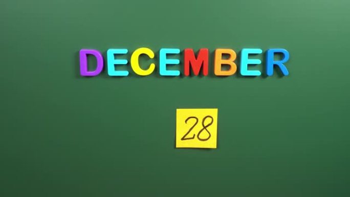 12月28日日历日用手在学校董事会上贴一张贴纸。28 12月日期。12月第二十八天。第28个日期号。