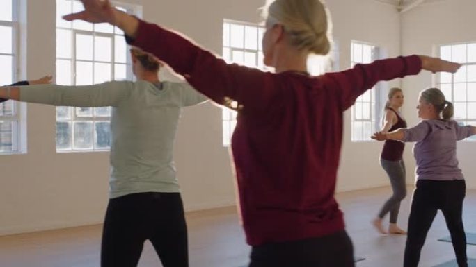 瑜伽课教练在日出时在健身工作室教成熟女性练习战士姿势享受健康生活方式