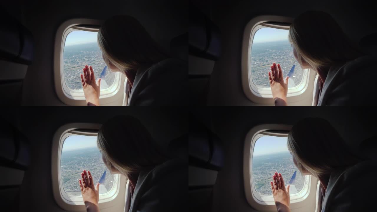 一名女乘客从客机的窗户往外看，看到大都市下面的地面