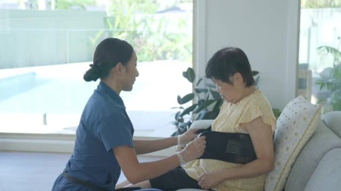家庭照顾者在家访期间为亚洲高级女性放回了支持带