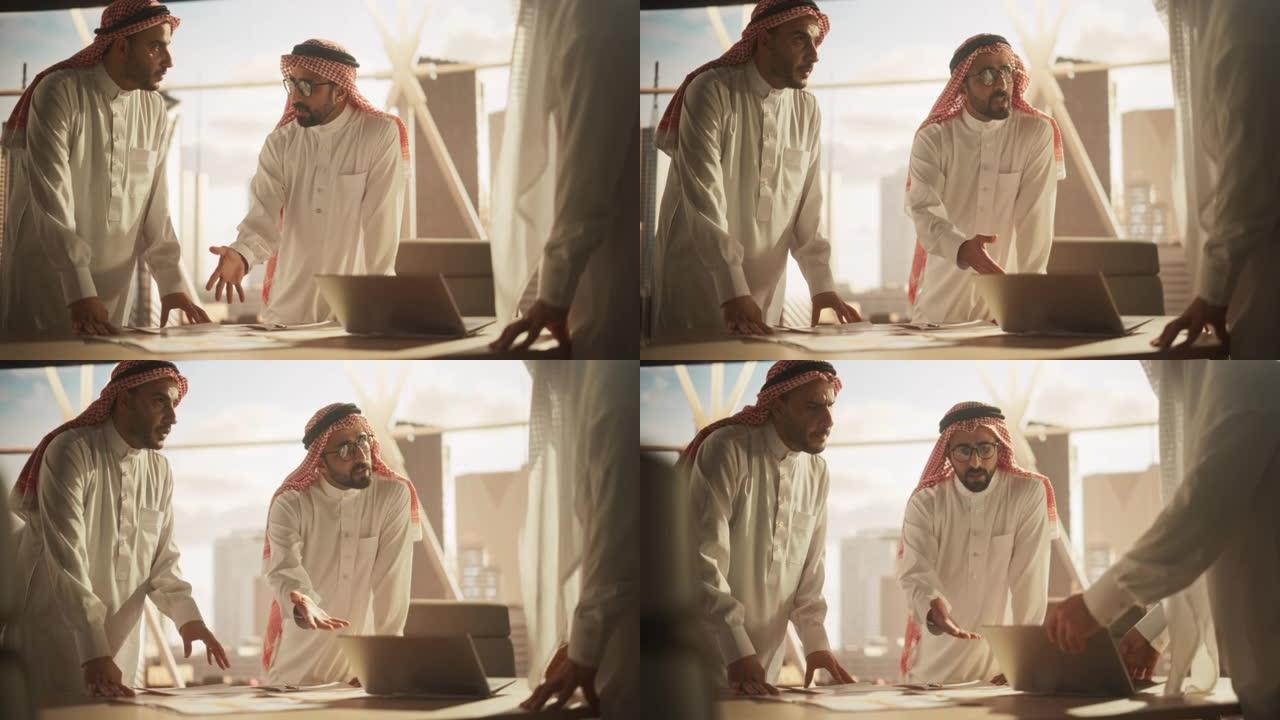 穿着白色传统服装的成功穆斯林商人举行办公会议，谈判和谈论金融机会。使用笔记本电脑。沙特、阿联酋、阿拉