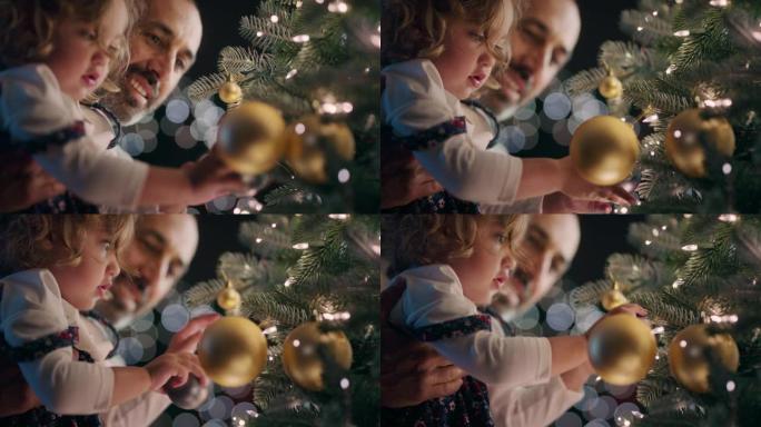 小女孩和父亲用漂亮的装饰品和小玩意装饰圣诞树孩子帮助爸爸在平静的夜晚在家悬挂节日装饰品4k镜头