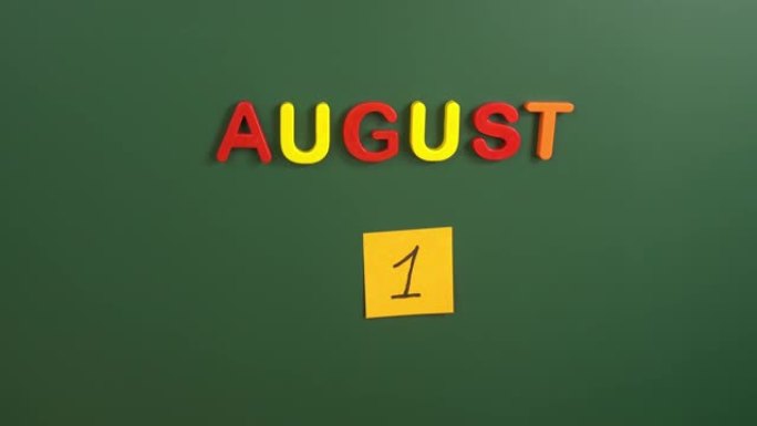 8月1日日历日用手在学校董事会上贴一张贴纸。1 8月日期。8月的第一天。第一个日期号。1天日历。一次