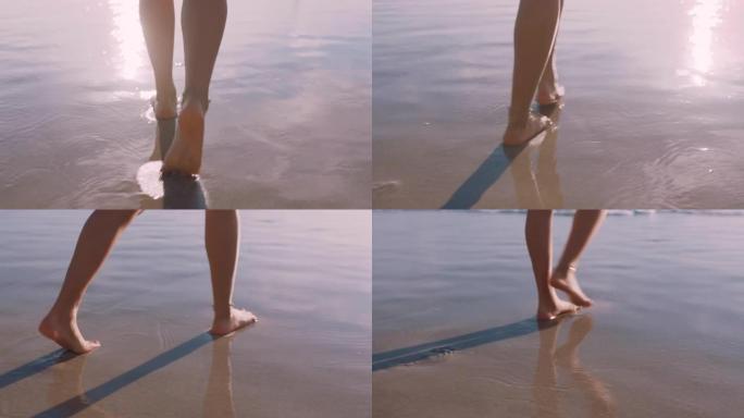 近距离女子脚赤脚走在海滩上日落留下脚印的沙滩女游客在暑假