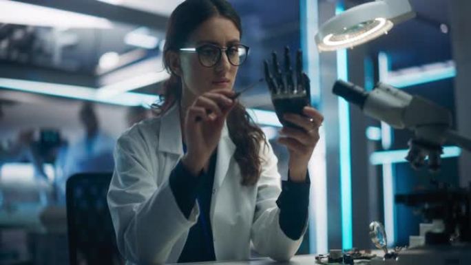 一位在技术研发公司工作的年轻女科学家的肖像，组装了一只创新的仿生假手。从事身体受损技术的工程师