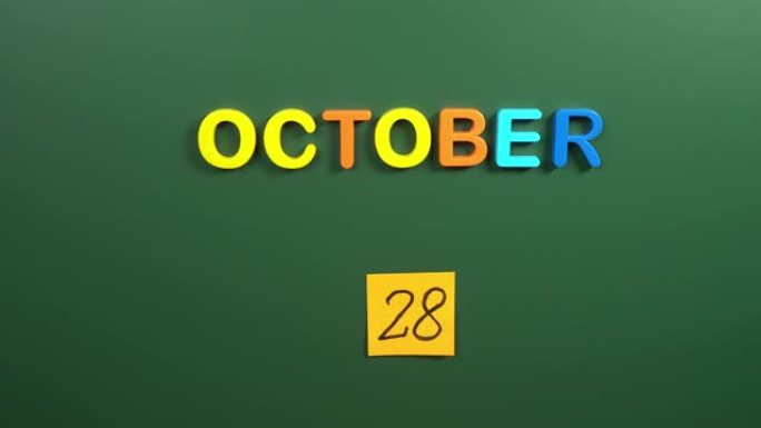 10月28日日历日用手在学校董事会上贴一张贴纸。28 10月日期。10月第二十八天。第28个日期号。