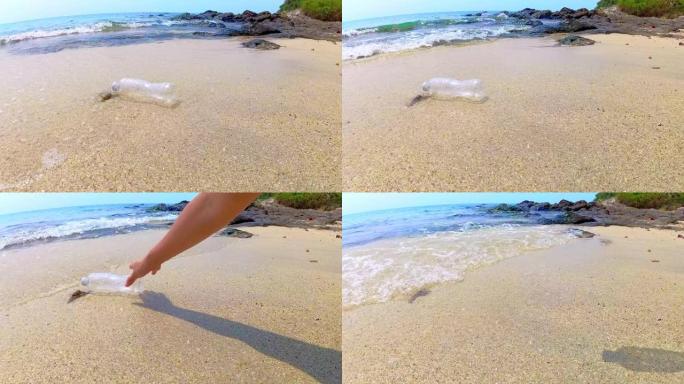 亚洲女人在海滩上捡起塑料瓶。良好的垃圾管理和海滩清洁减少了一次性塑料废物造成的海洋污染。环保、生态理